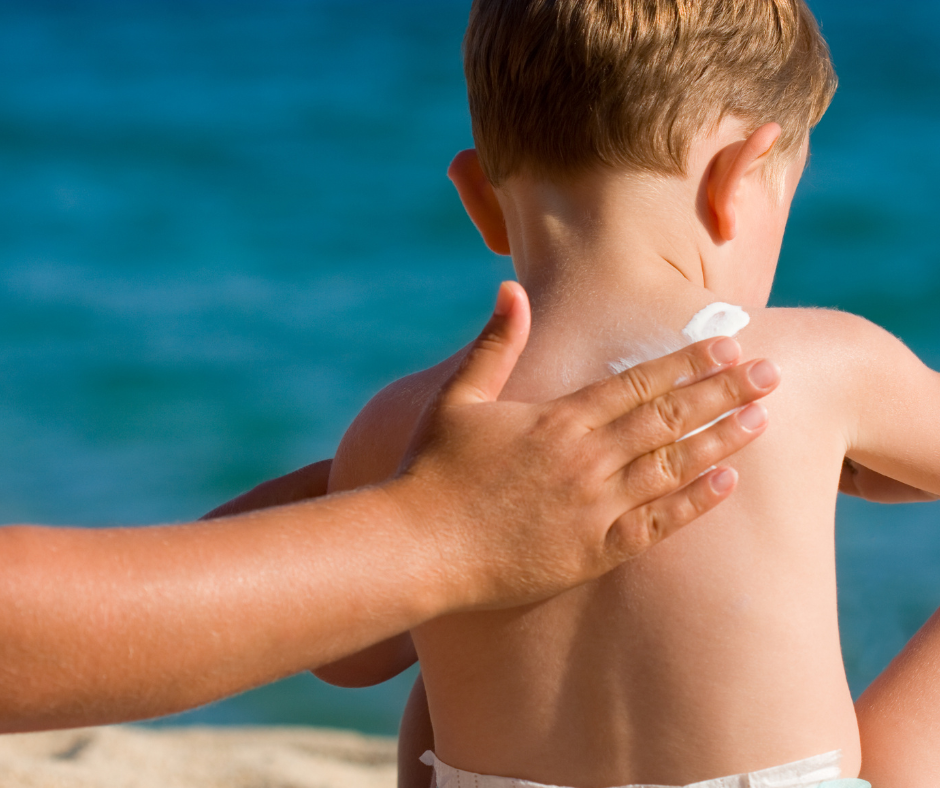 Parent applying sunscreen to toddler